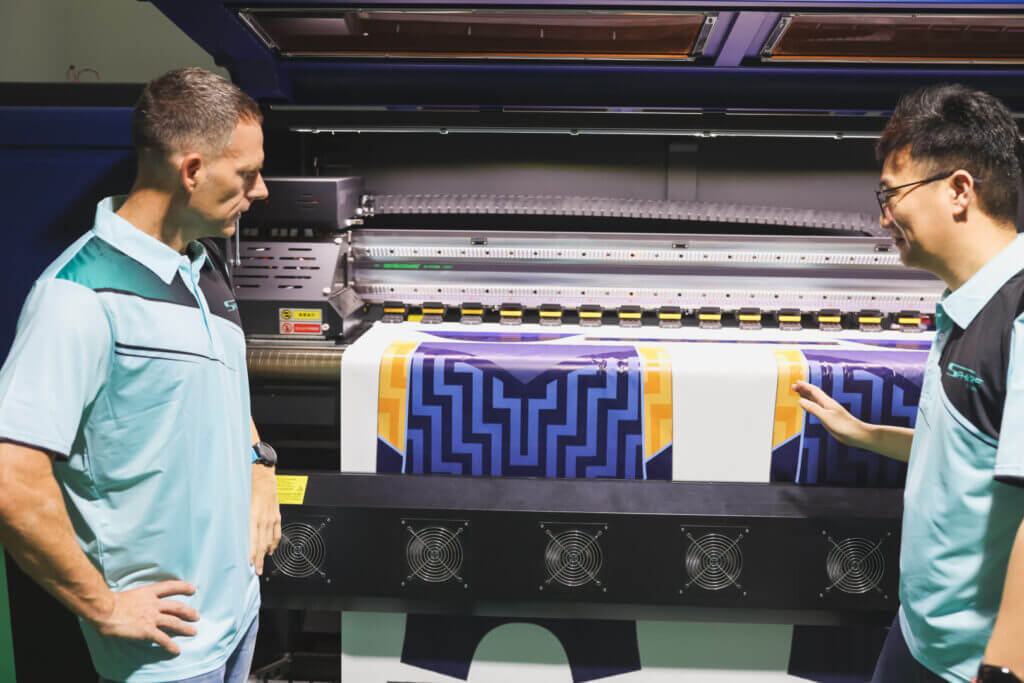 Sam Clay and Eric Fan inspecting the process of custom cricket jerseys production.